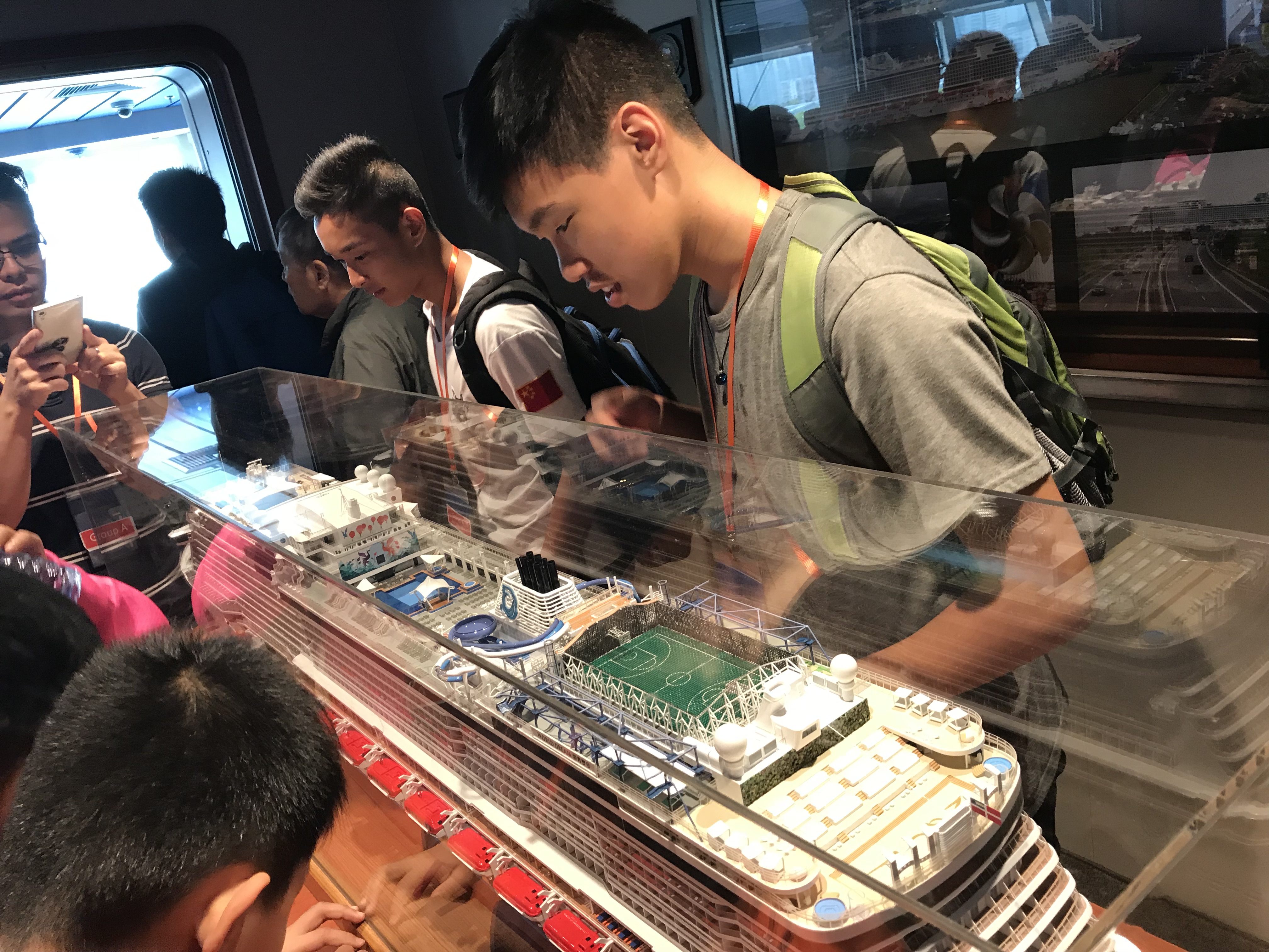 Participants looking at the cruise model with great curiosity in the Bridge Viewing Room.